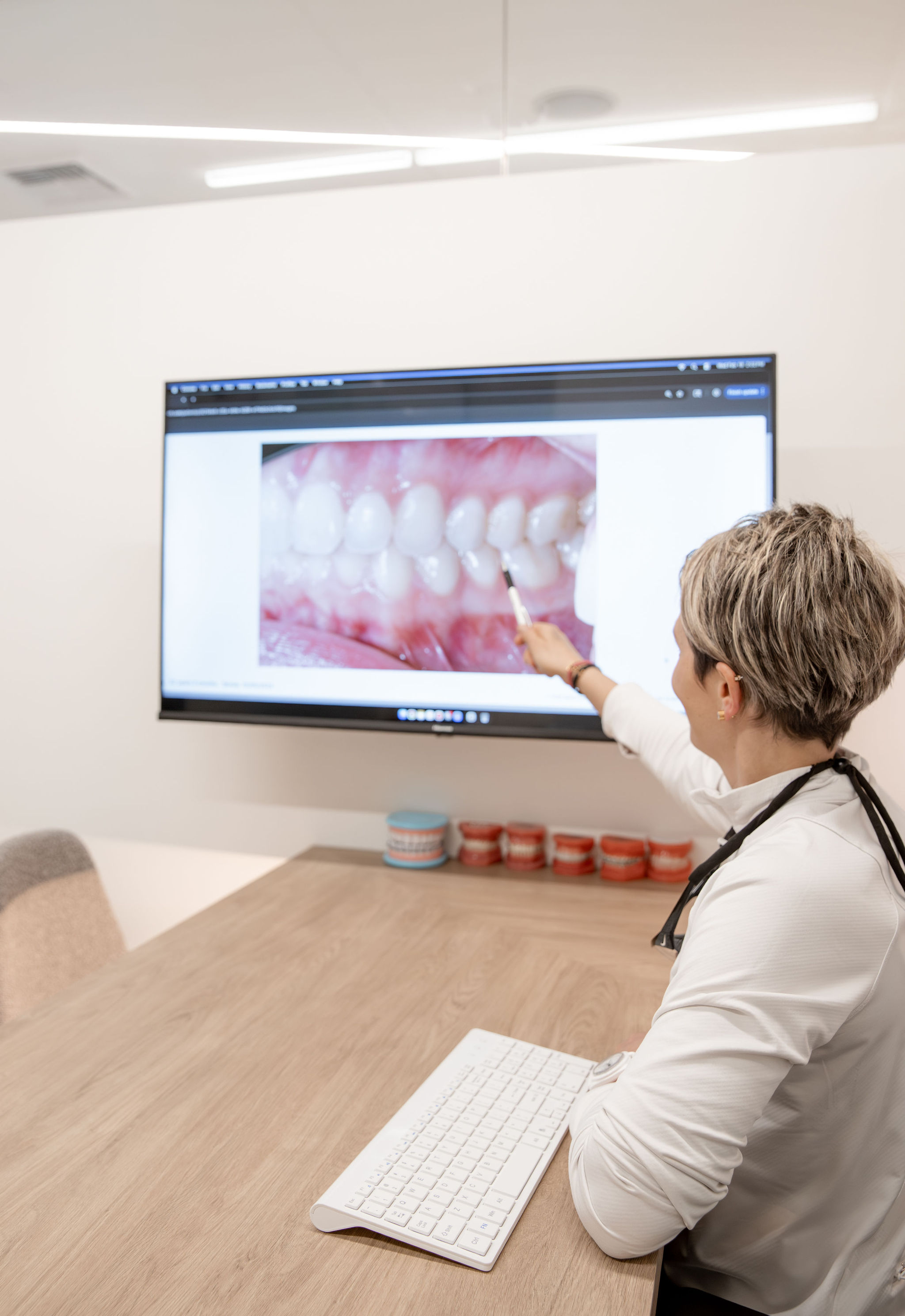 Dr. Alissa Borda pointing to a dental image on a large monitor during an orthodontic consultation at Islander Orthodontics, serving families near Bellevue, WA